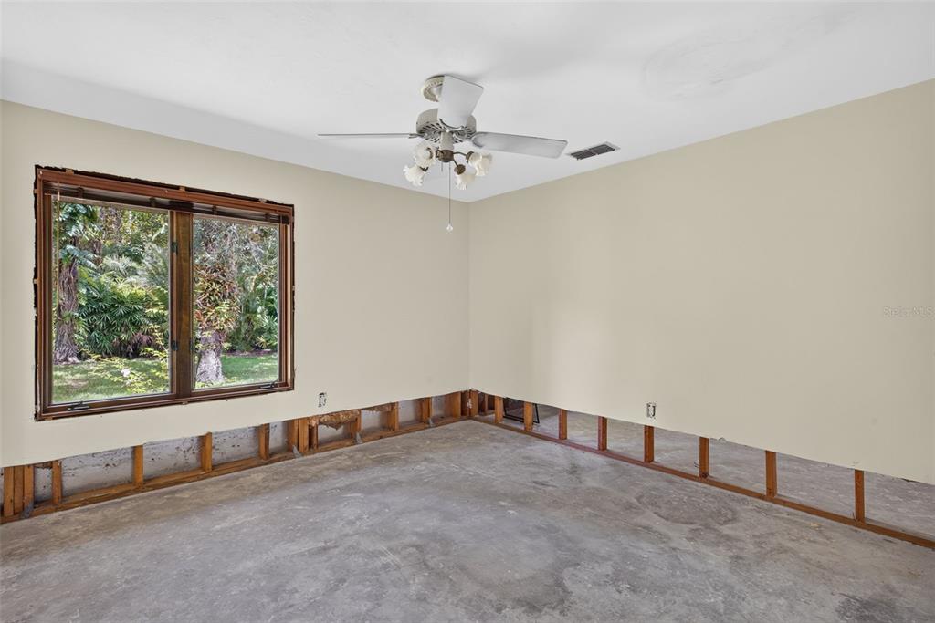 Second bedroom with Ceiling fan and window overlooking the lush grounds