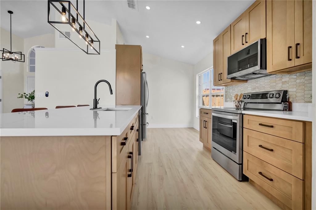 Chefs kitchen featuring LG appliances, modern shaker cabinets, calcatta quartz.