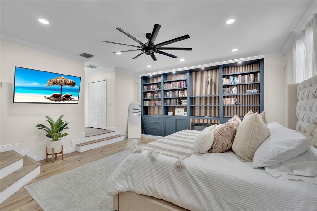 A moody and inviting primary retreat, thoughtfully designed with custom built-ins, an electric fireplace, and a unique step-down layout that adds character and distinction.
