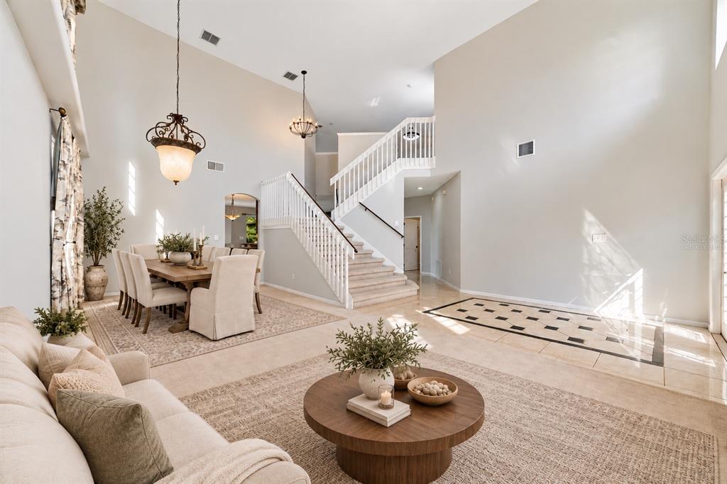 The formal LIVING ROOM/DINING ROOM COMBO share an elegant, open setting enhanced by 2-STORY CEILINGS where a chandelier and decorative ceiling medallion create a lovely atmosphere for hosting holidays and special occasions. Virtually Staged
