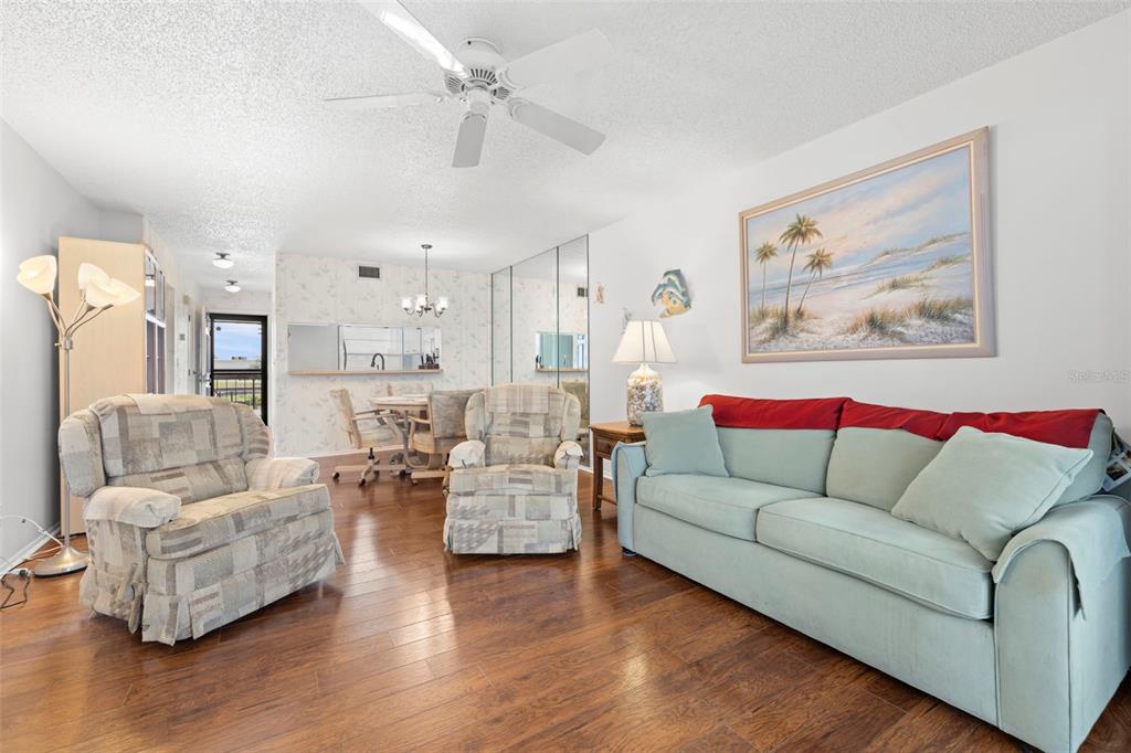 View of living/dining room toward kitchen and entryway. This home comes fully furnished!  You can just move right in!