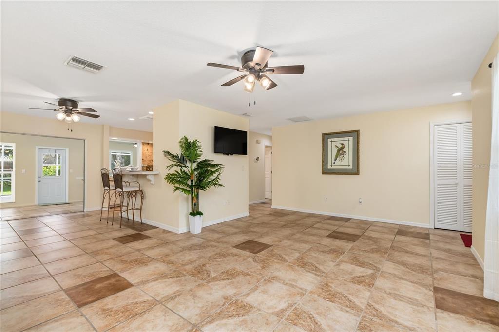 Showing off living room on right, kitchen center and dining area on left