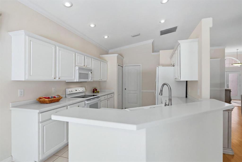 Bright white kitchen with island, modern cabinetry and abundant natural light