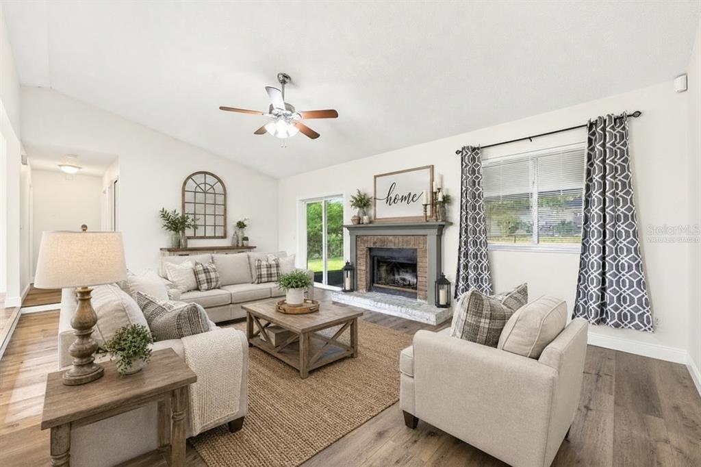 Step inside to discover a bright and inviting Living Room filled with NATURAL LIGHT and centered around a cozy WOOD-BURNING FIREPLACE, creating the perfect gathering space. Virtually Staged