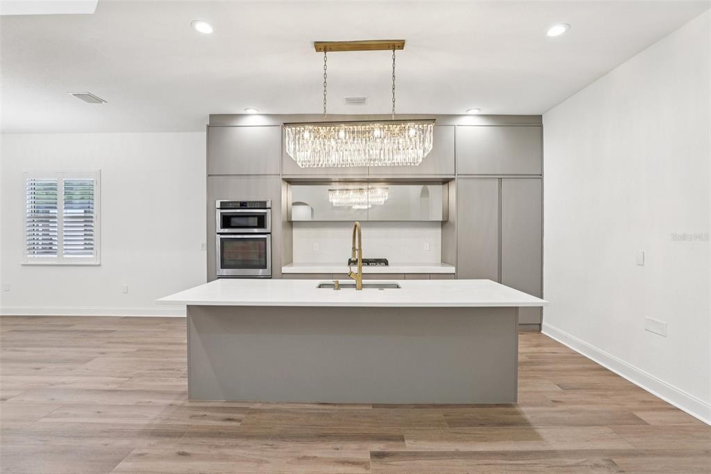 The kitchen is sleek and functional with a LARGE ISLAND for bar seating, upgraded fixtures, and a design that flows effortlessly into the main living and dining spaces – perfect for entertaining.