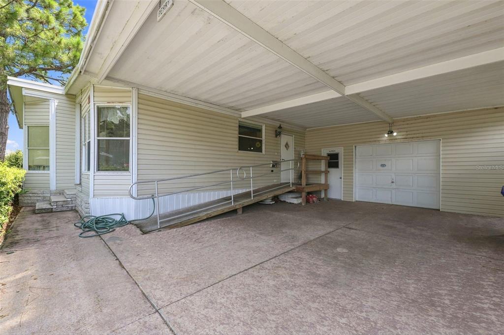 Large carport with HUGE oversized garage/workshop.