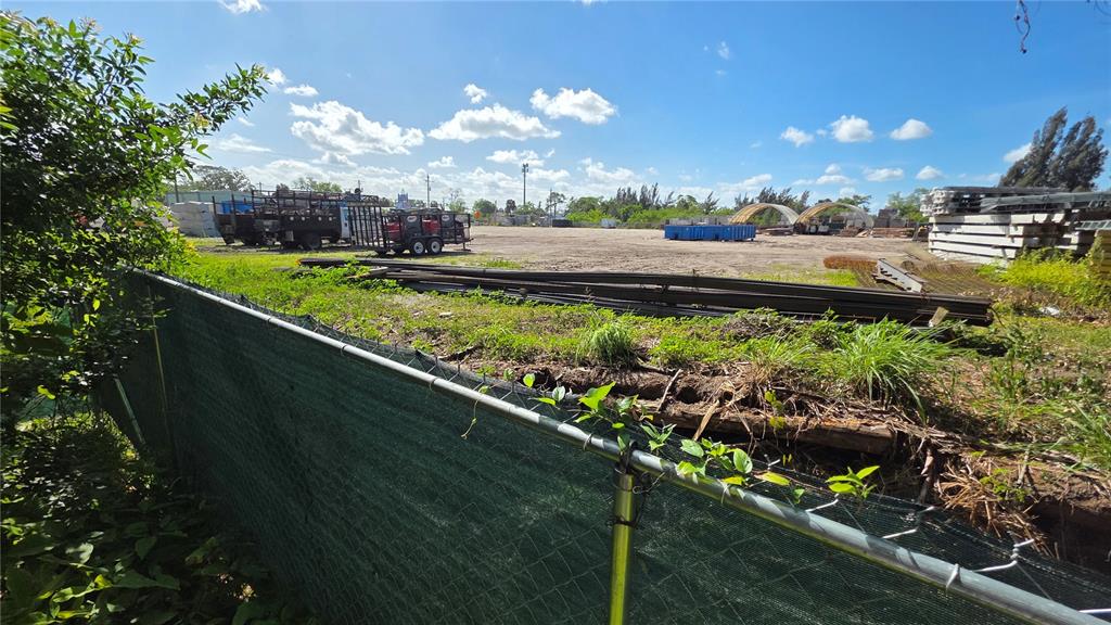Looking over the Green Fence at end of 49th Street cul-de-sac.ZONING CONSIDERATION: In 2005, this Southerly neighboring commercial lot (046606 - see pic# 2) wasapproved by Hillsborough County for 'rental, service sales of heavy equipment and commercial vehicles' – aHIGH COMMERCIAL ZONING, which has the potential to be extended to Lot B & possibly even to Lot C.