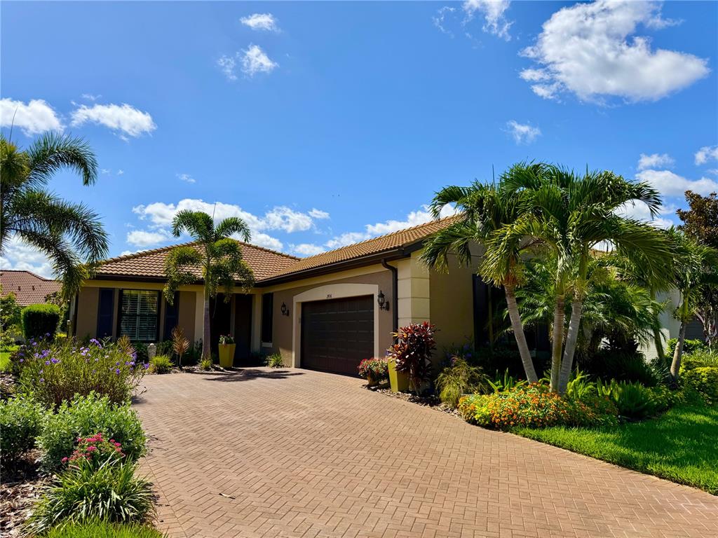Beautifully landscaped home with a paver driveway