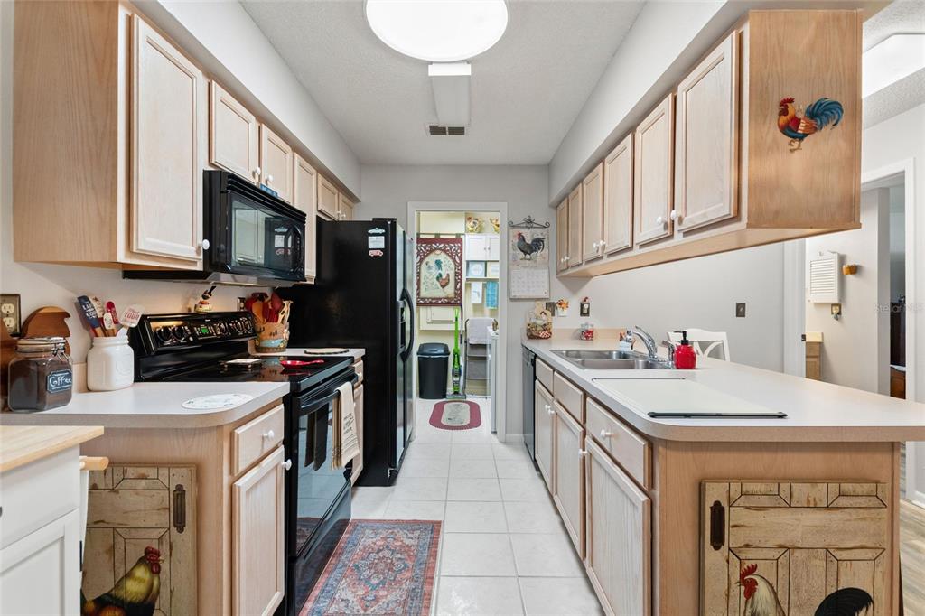 The galley-style kitchen has loads of cabinetry and counter space.  The laundry room is conveniently located at the end of the kitchen