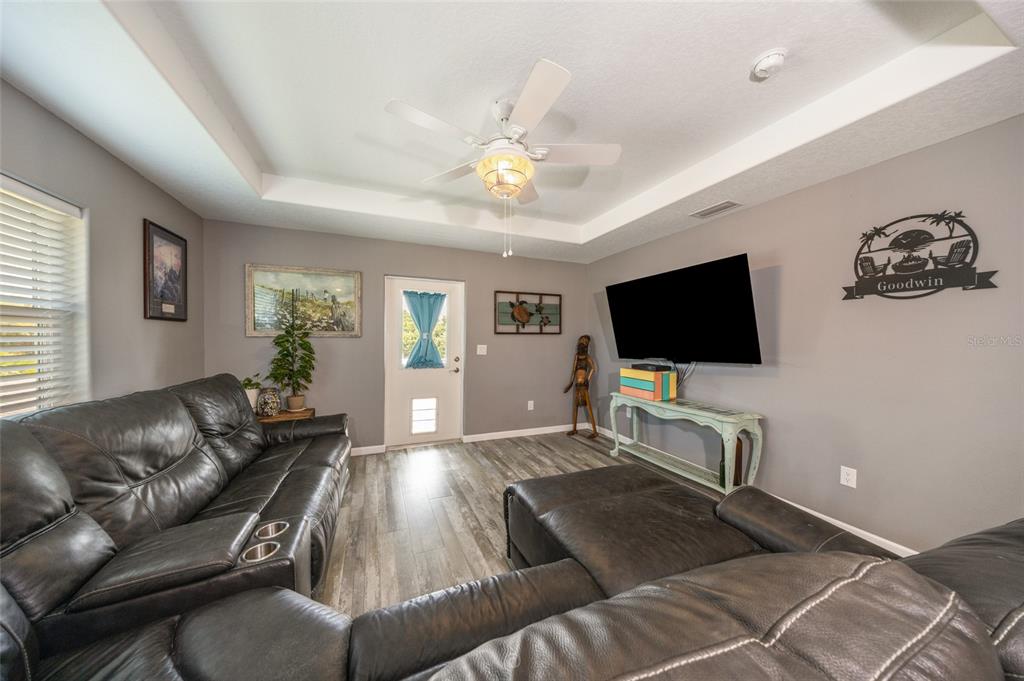 Family room with tray ceiling & the door leading to front deck