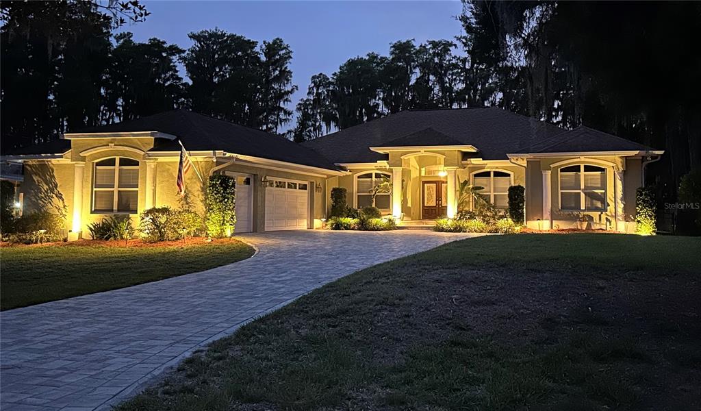 Luxury waterfront living on King Lake — Welcome to 5035 Conner Drive, a private 5.21-acre estate featuring 100 feet of ski-lake frontage, a spacious 5-bedroom, 3-bath residence, 3-car garage, pool, and beautiful Florida surroundings. This impressive evening view showcases the home’s welcoming architecture and peaceful estate setting.