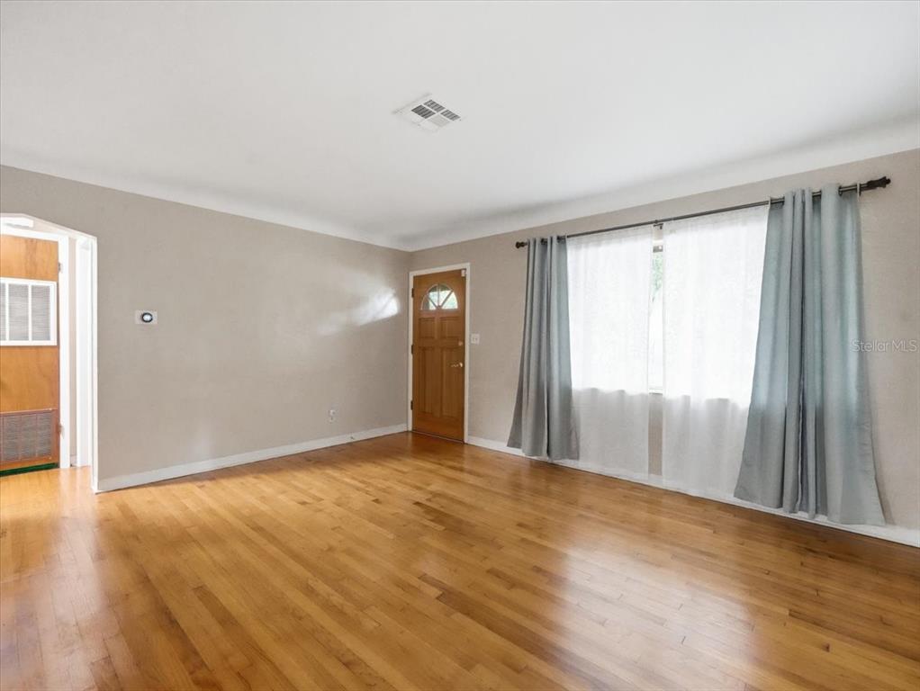 Living Room with original hardwood flooring, cove ceilings and windows bringing in the natural light!