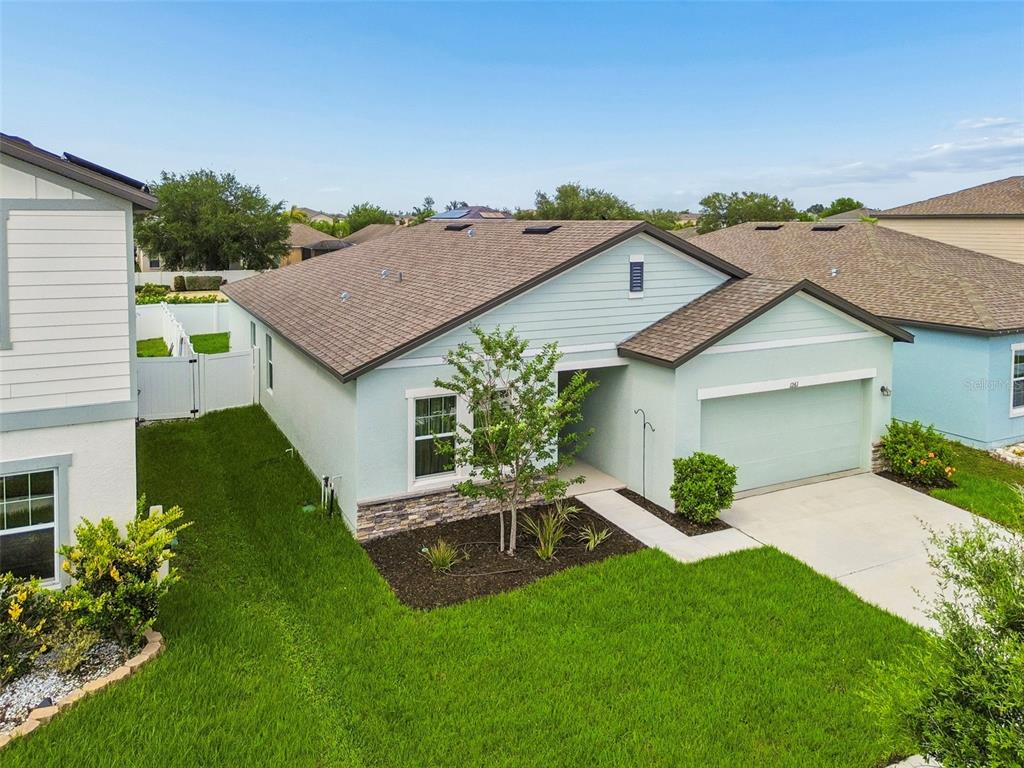 Beautiful modern curb appeal! Featuring contrasting dark trim, stone accents, and lush lawn!