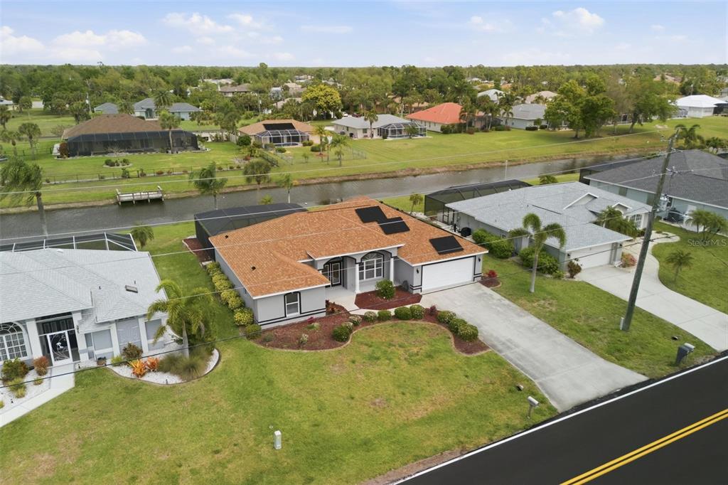 Wide aerial view showcasing no-flood-zone lot, pool, and tranquil surroundings