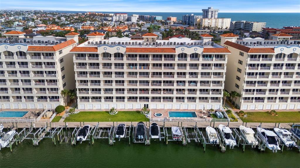 Exterior waterfront of unit 604 , with private docks, pool, spa, kayak, and fishing pier on BOCA CIEGA BAY leading to the GULF OF MEXICO