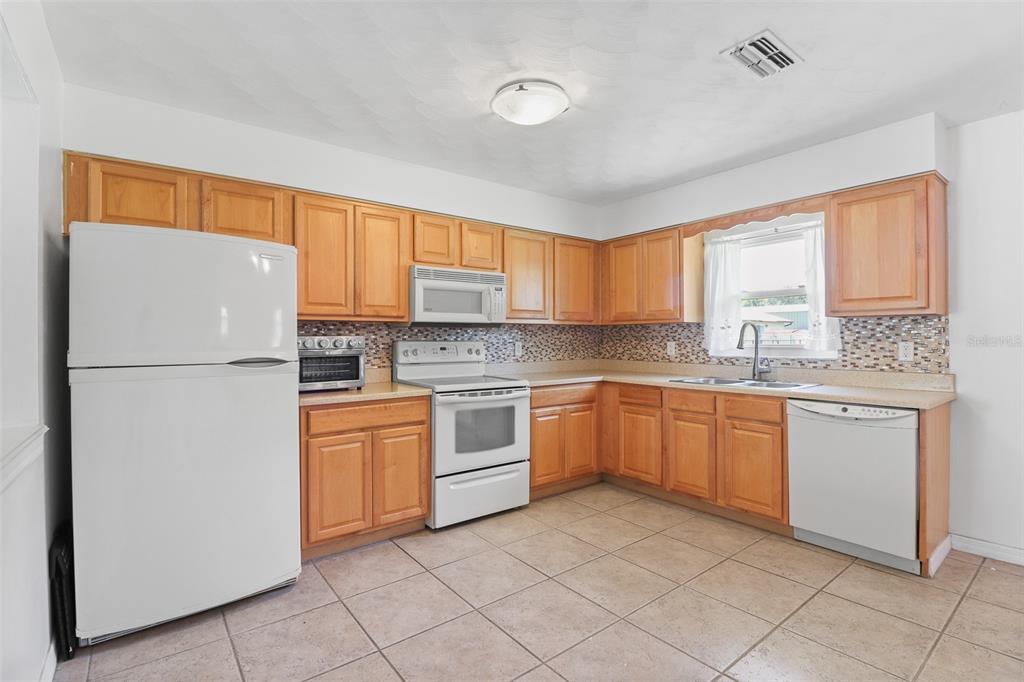 Renovated kitchen, solid wood cabinets, laminate countertops with beveled edge, coordinating backsplash