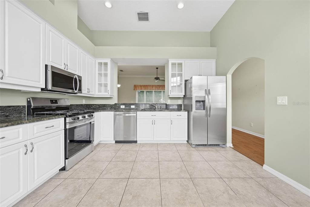 Spacious kitchen featuring granite countertops, stainless steel appliances, abundant cabinetry, and generous workspace.