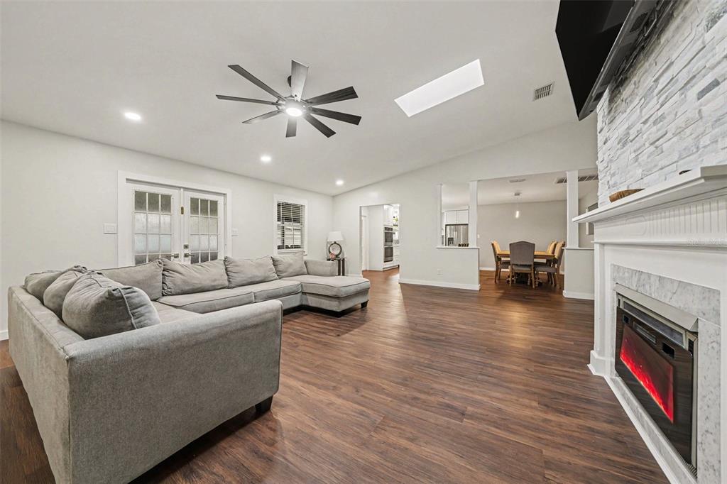 Spacious Family Room featuring dual Electric Fireplace & Stone tile accent wall