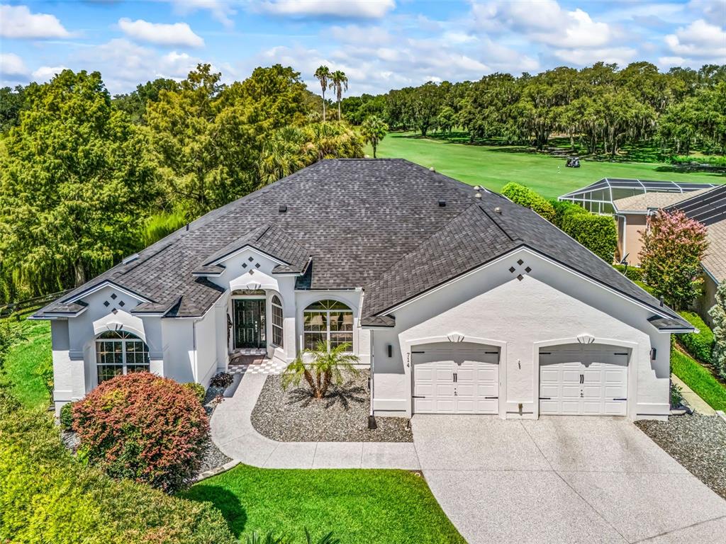 Beautiful aerial view showcasing this spacious 2,774 sq. ft. Premier home with an expansive driveway, EXPANDED garage, attractive architectural details, and mature landscaping.