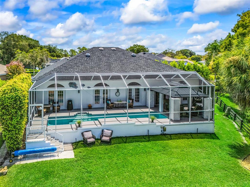 Resort-style outdoor living features a large screened pool and spacious pool deck, creating an inviting setting for relaxing, entertaining, and enjoying the Florida lifestyle.