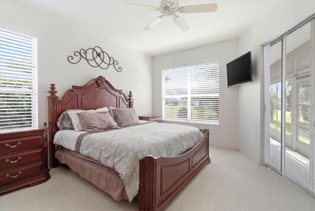 Master Bedroom w/ Slider to the Enclosed Sunroom, Dual Closets, a Convenient 3rd Closet & Ensuite w/ Dual Sinks, Water Closet & Tiled Shower