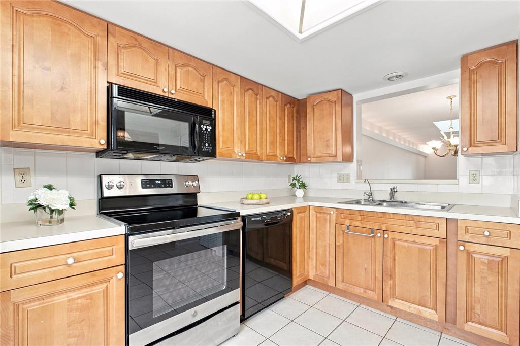 Spacious kitchen with updated cabinetry & convenient pass-through window to the main living~