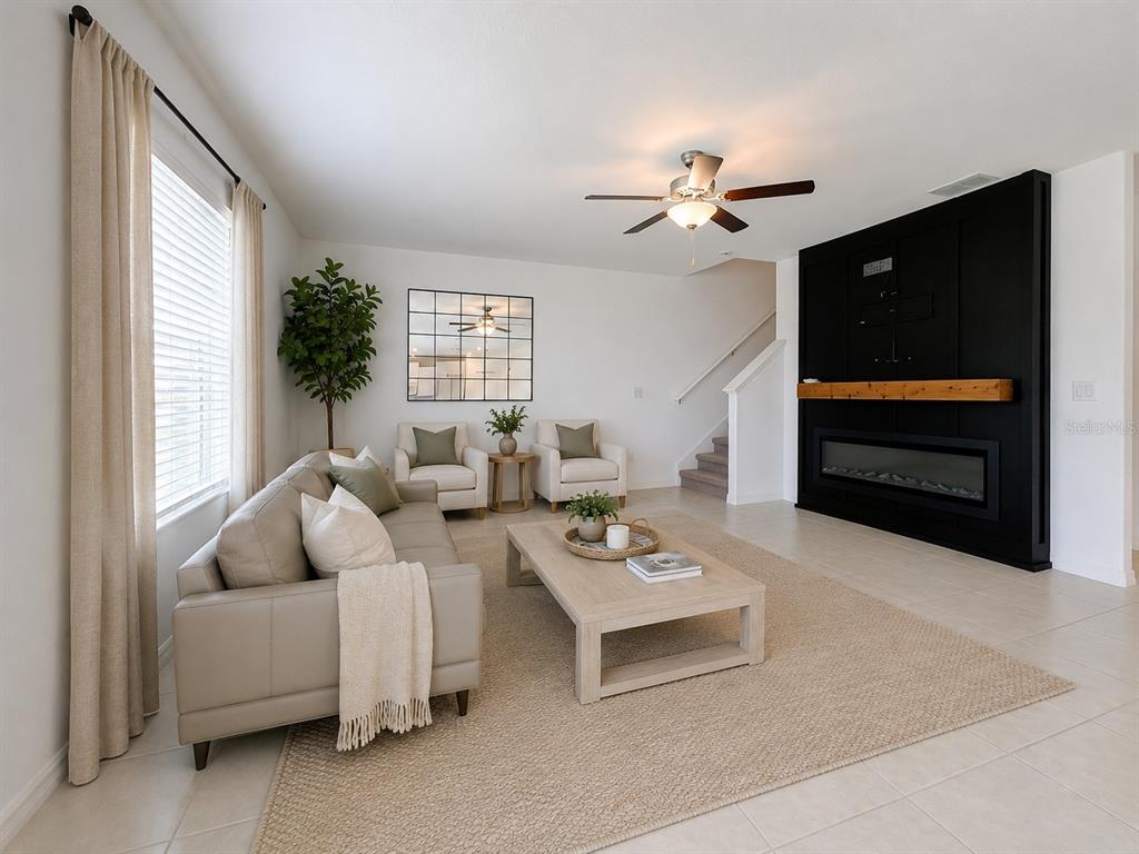 living area with accent wall and built-in electric fireplace