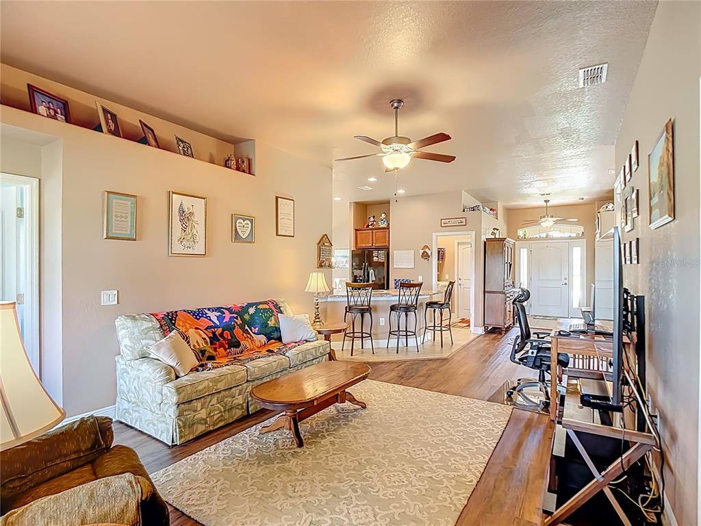 Looking from the living room to the breakfast bar and the front door with transom windows on either side of the door and the top of the door.