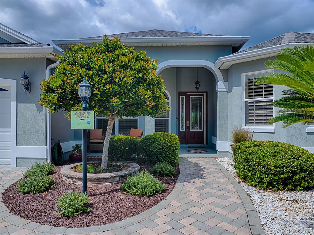 LOVELY ENTRANCE WITH A FRONT PORCH AND LEADED GLASS FRONT DOOR WITH SIDELITE.