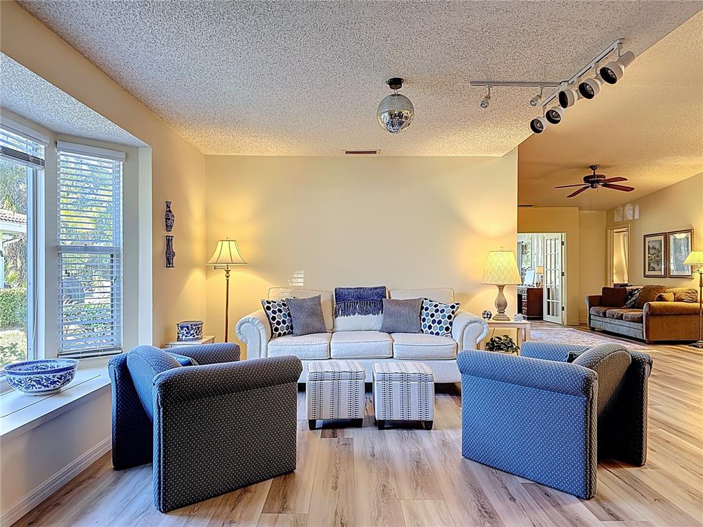 Living room with bay window and track lighting. The bay window has a bench seat and storage area.