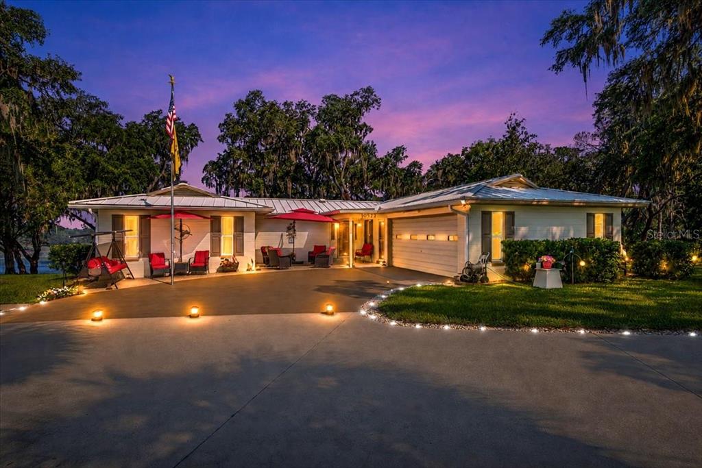 A breathtaking twilight view showcases the home's inviting outdoor living spaces, elegant lighting, and timeless curb appeal.