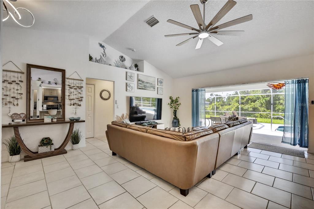 Living room with vaulted ceilings-entry to the pool area.