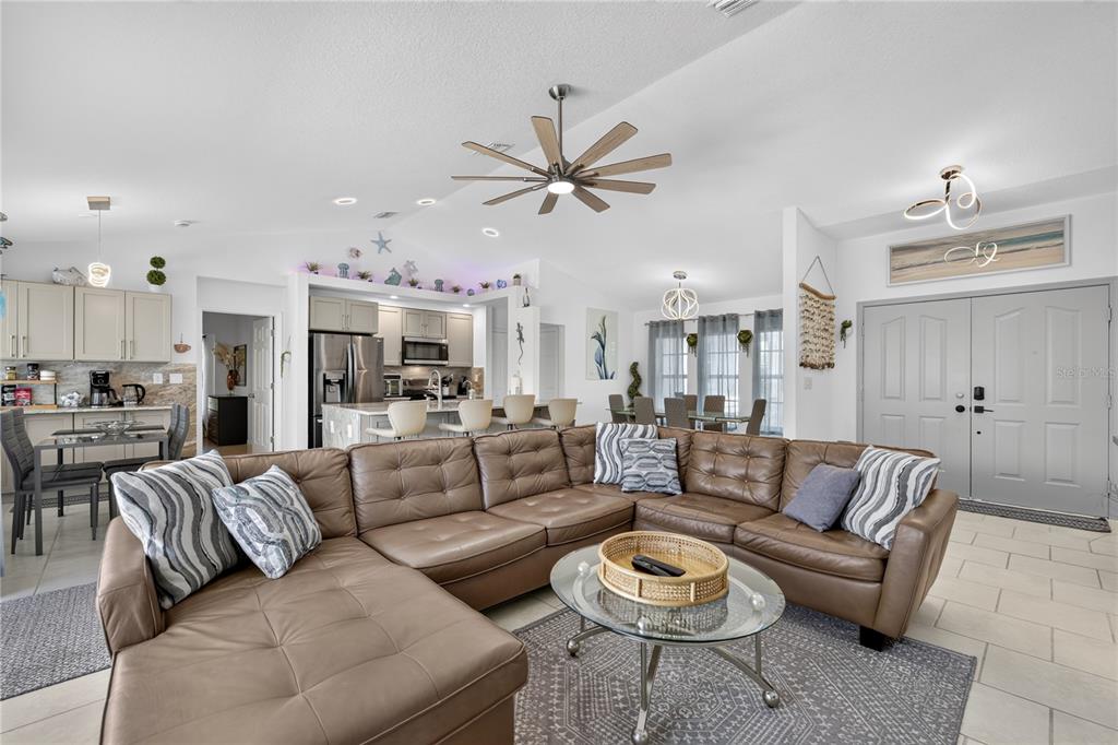 Open concept living/kitchen/dining area with vaulted ceilings.