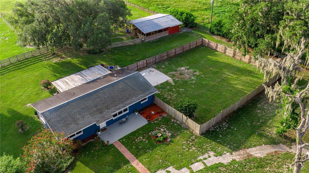 Overview of the home, fenced-in side yard, and the barn area.