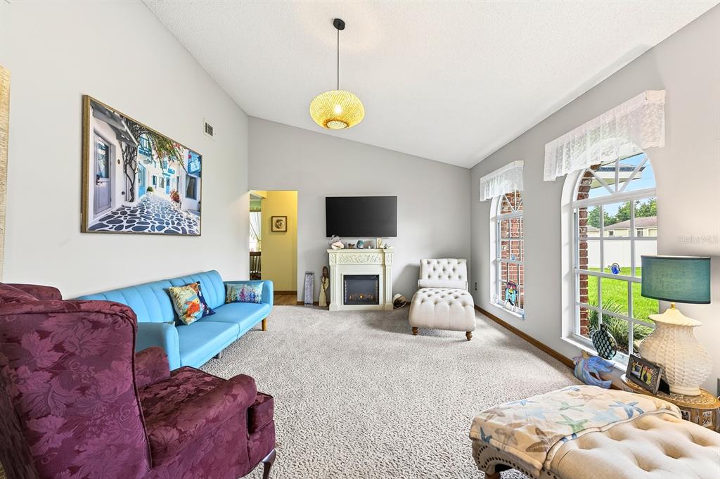 Step inside to a formal Living Room featuring plush carpeting and three ELEGANT ARCHED WINDOWS that fill the space with natural light.