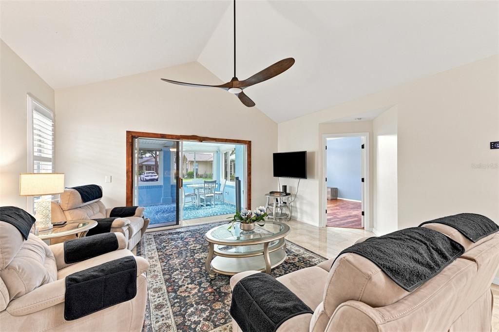 Walk in to a spacious and beautiful living room with plantation shutters, custom ceiling fans and high ceilings!