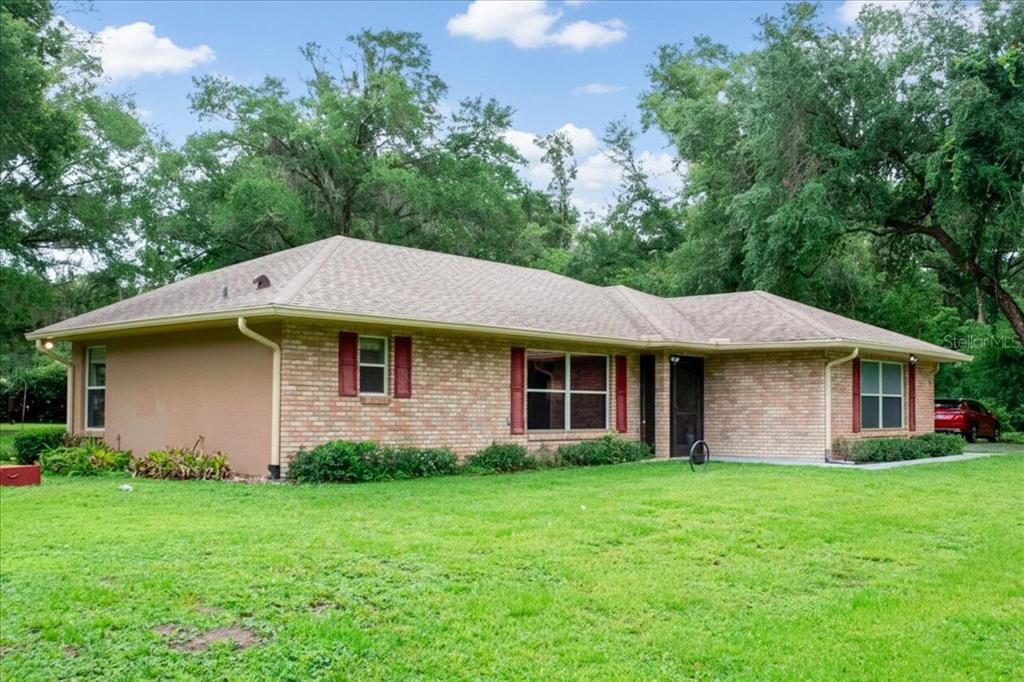 Angled exterior view showcasing the brick construction and covered front porch.