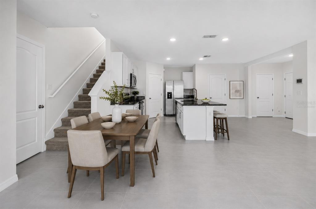 Virtually staged dining area overlooking the open-concept kitchen