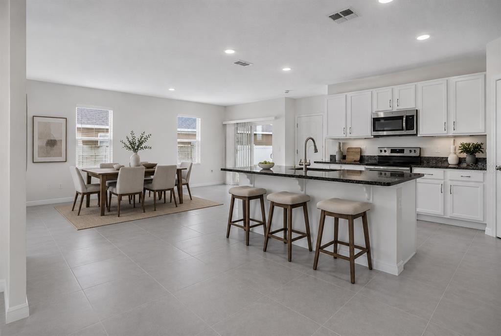Virtually staged kitchen with granite countertops and large center island