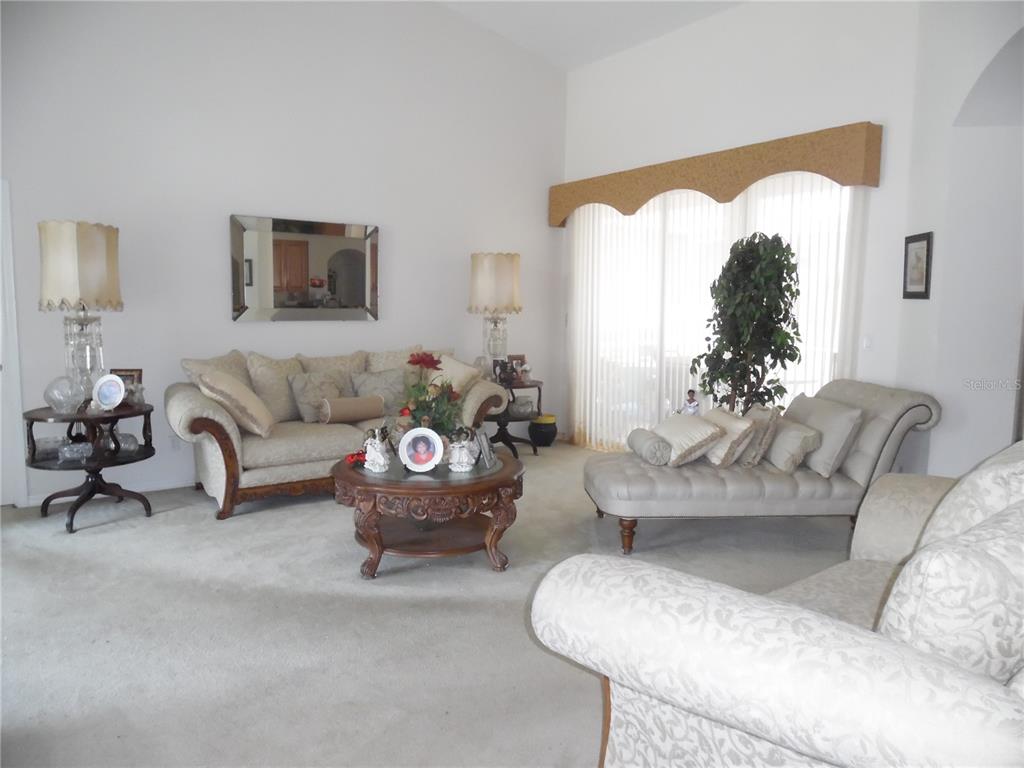 Formal living room upon entering home with sliding glass doors leading to covered patio