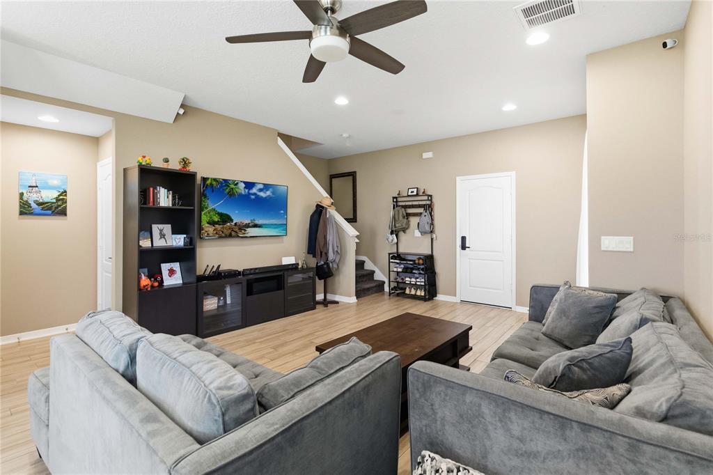 Spacious living room with ceiling fan and flexible layout