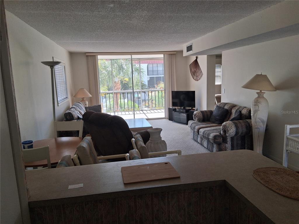 Standing in kitchen looking into living room and screen porch
