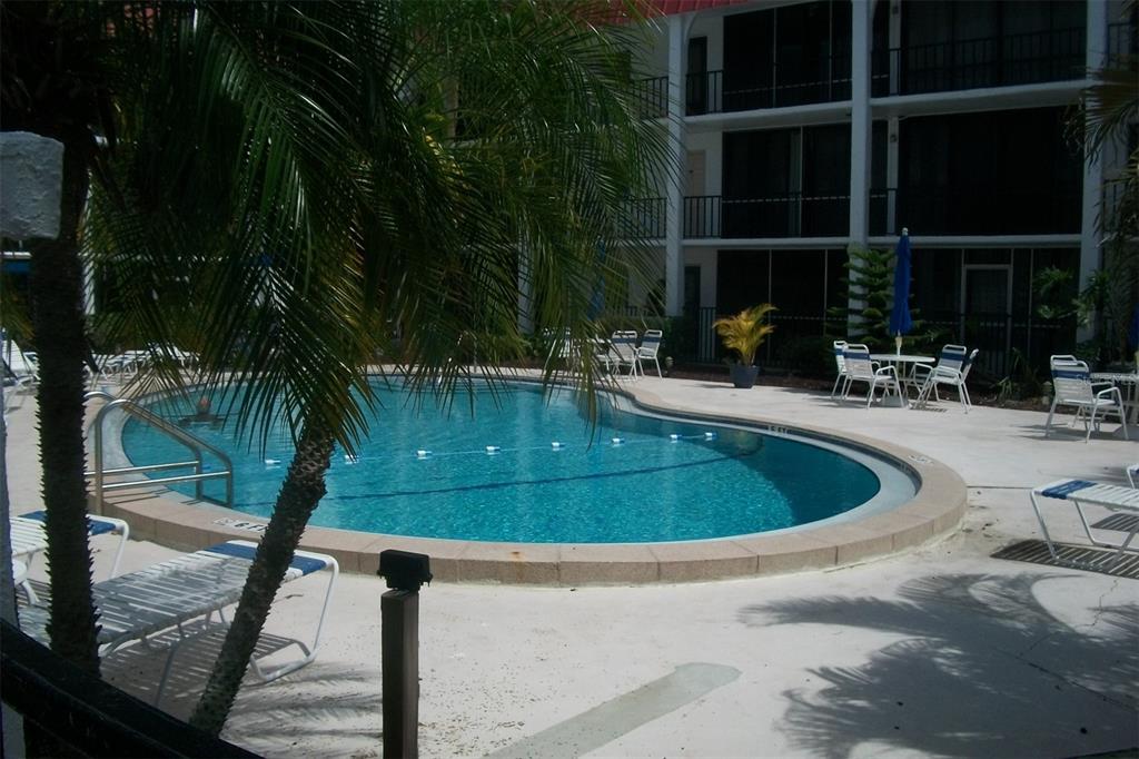 Standing in screen enclosed balcony overlooking community pool