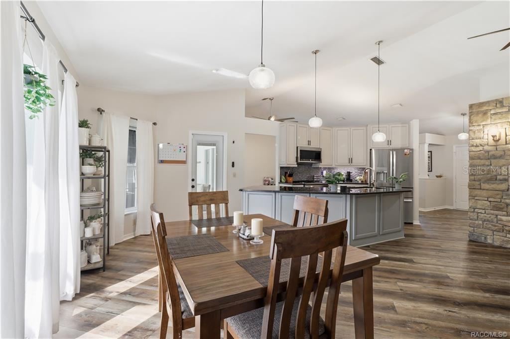 DINING AREA & KITCHEN- Inviting dining area w/natural light, easy access to the pool area & an open connection to the updated kitchen.