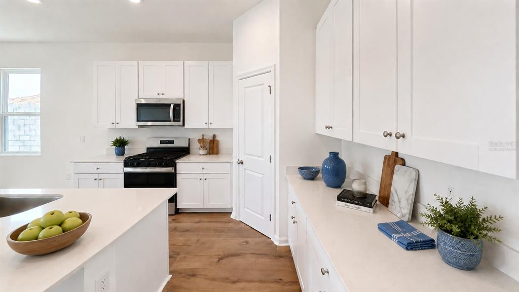 Virtually Staged White Modern Kitchen with Warm Wood Floors