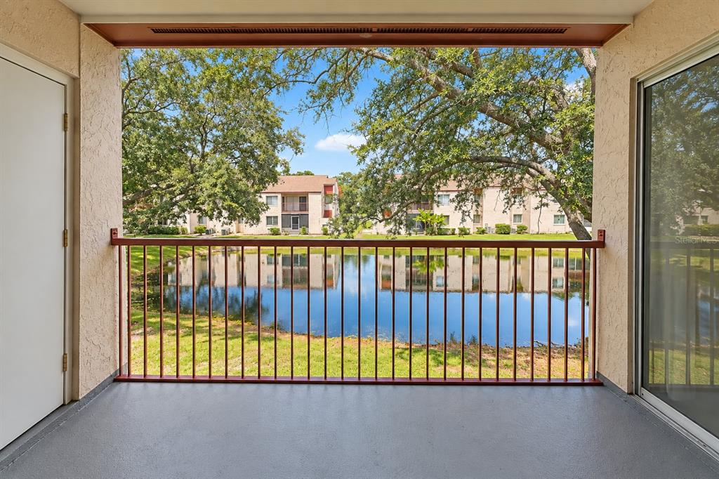 Tranquil pond view from balcony.  Exterior storage room at left.