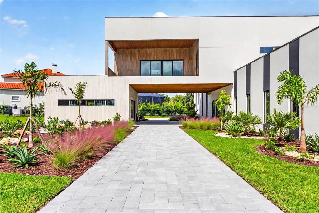 Driveway view of portico entrance of home. Virtual.