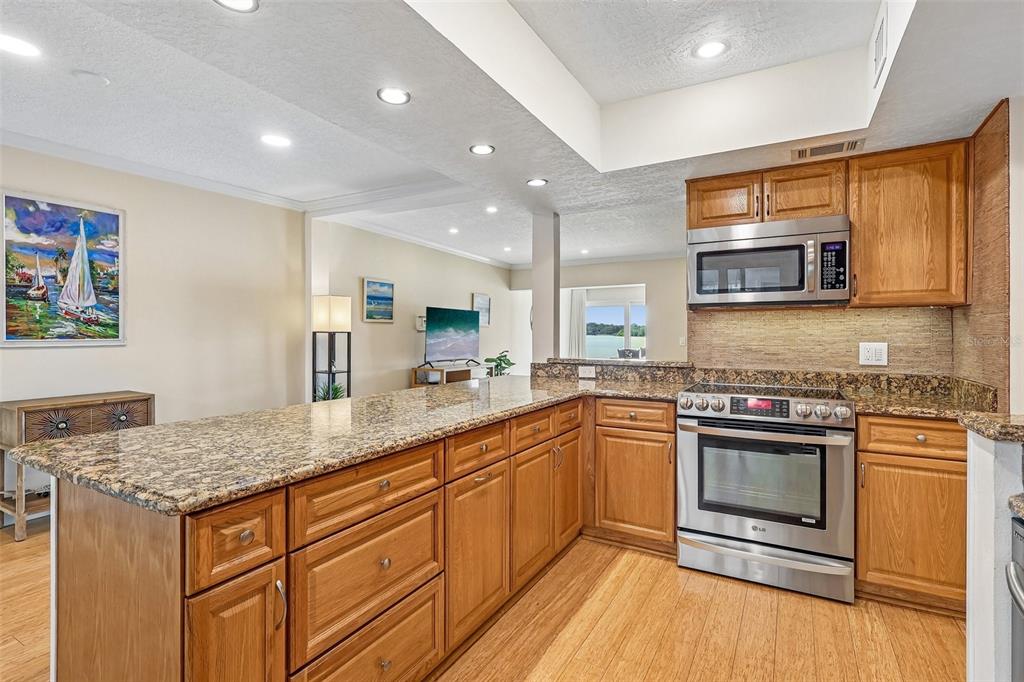 The BEAUTIFULLY UPDATED Kitchen is designed for both everyday living and entertaining, featuring GRANITE COUNTERTOPS, stainless steel appliances, abundant cabinetry, a breakfast nook, a NEW backsplash, and a NEW REFRIGERATOR.