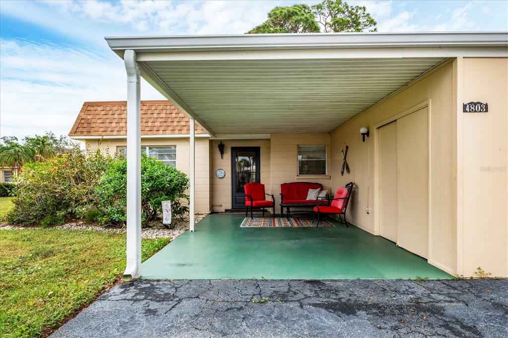 Front of villa with attached carport and storage closet
