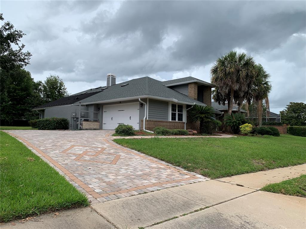 2 car garage with paver driveway and extra parking space that extends beyond the garage Home also has solar hot water panels for the pool on the roof.